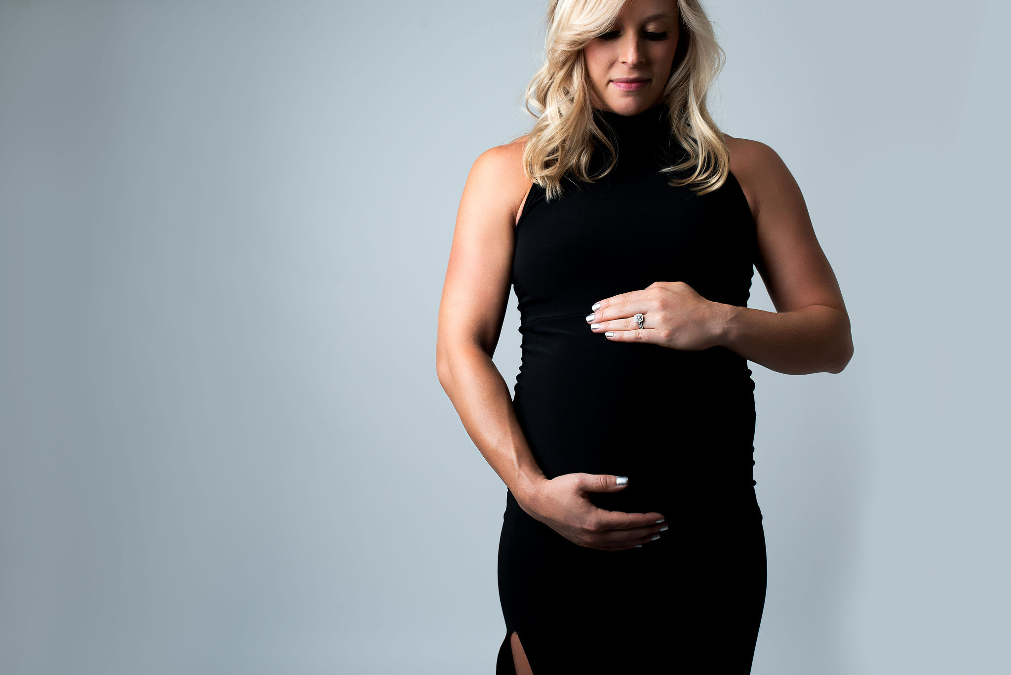mom to be in a black sleeveless maternity gown holding her bump